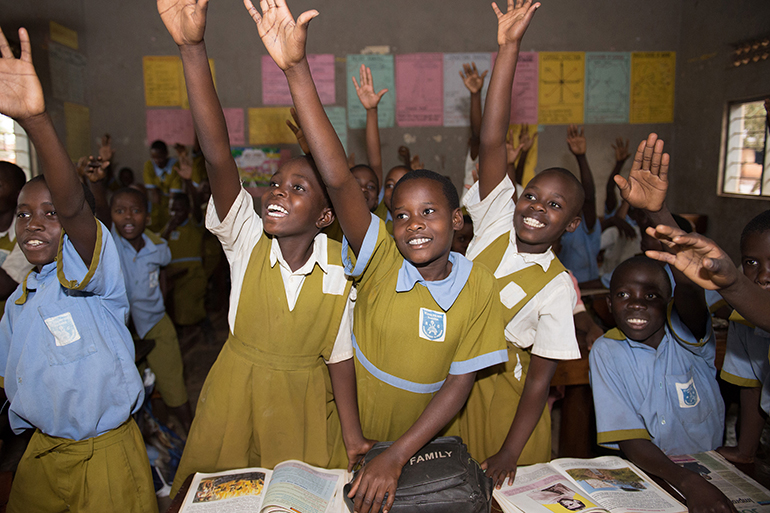 African schoolchildren raising their hands in class. COALITION FOR GOOD SCHOOLS.
