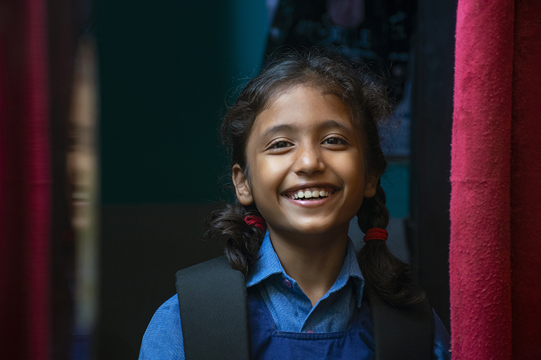 Young Asian schoolgirl smiling at the camera. COALITION FOR GOOD SCHOOLS.